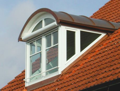 Im Münchener Wohnhaus eingebaute Dachgaube mit Rundach, seitlicher Verglasung und weißen Fensterrahmen
