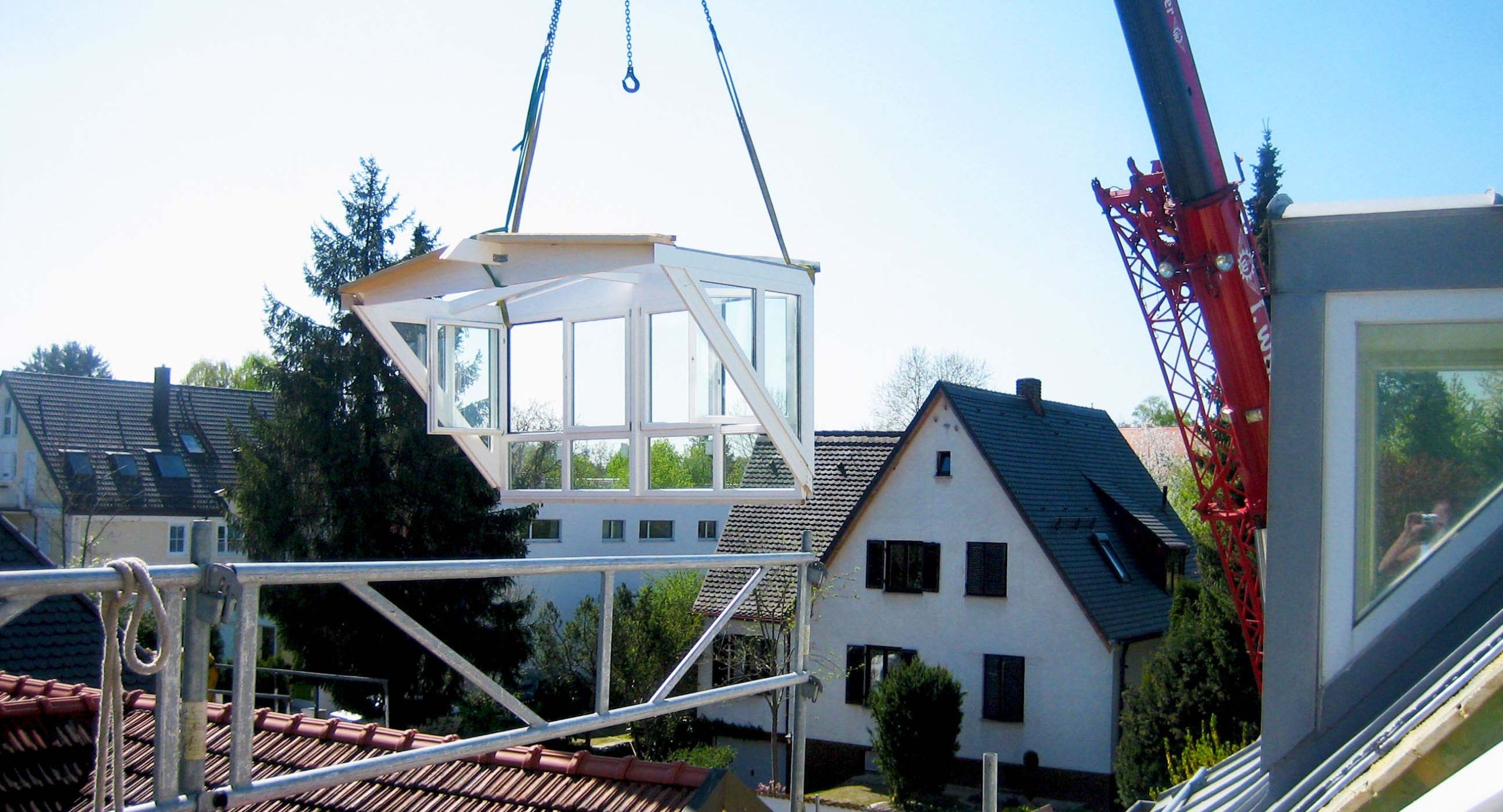 Einbau einer am Kran hängender, vollverglaster Dachgaube in ein Wohnhaus in der Münchener Umgebung