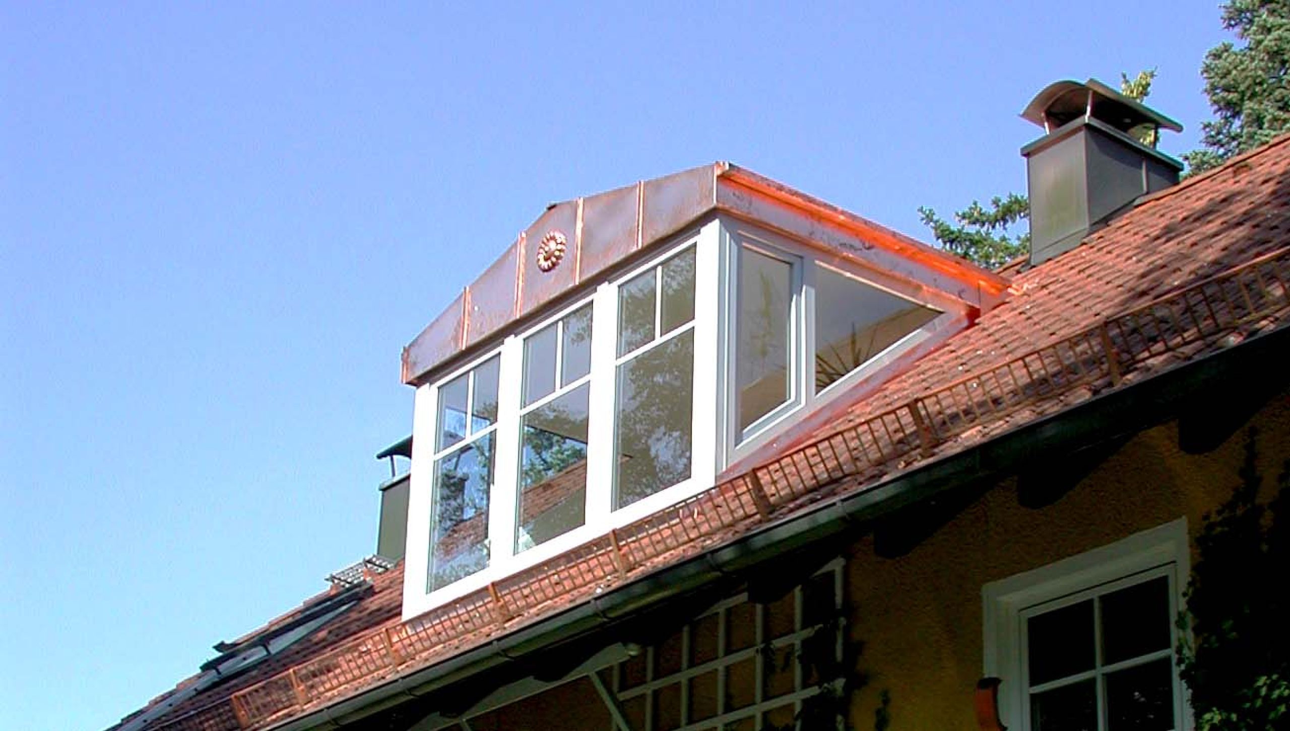 Seitlich- und frontal verglaste Dachgaube eines Wohnhauses in der Münchener Umgebung mit kupferner Dachverkleidung