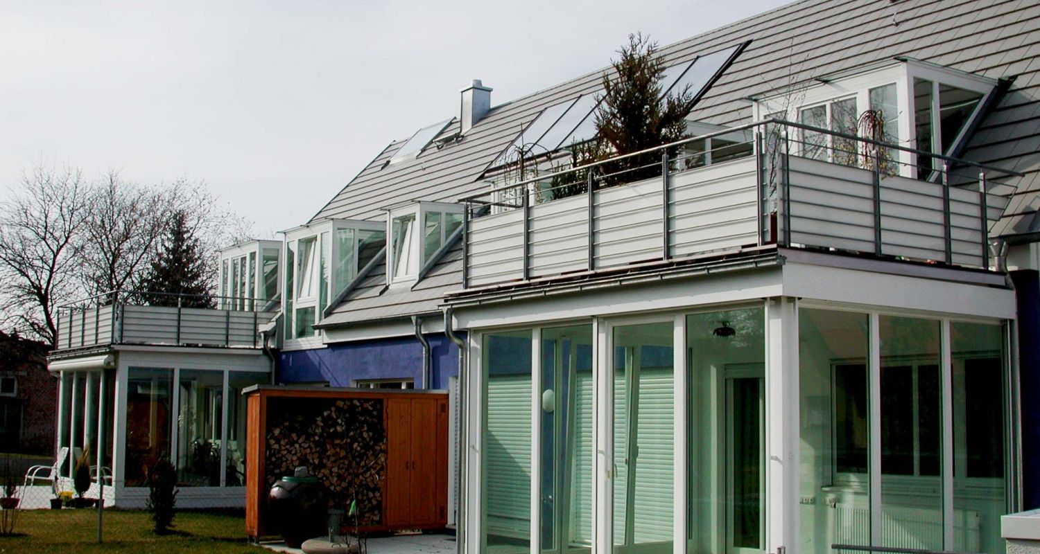 Münchner Wohnhaus mit mehreren Dachgauben-Varianten, jeweils seitlich verglast mit weißen Fensterläden